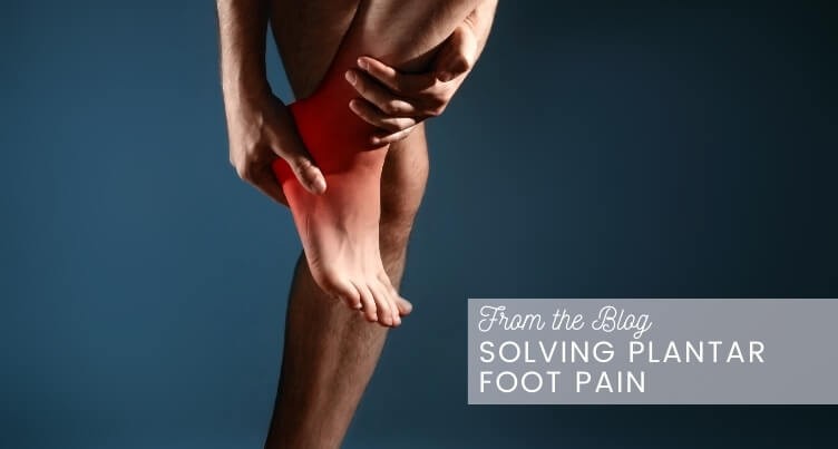 Someone using a tennis ball to massage their foot.
