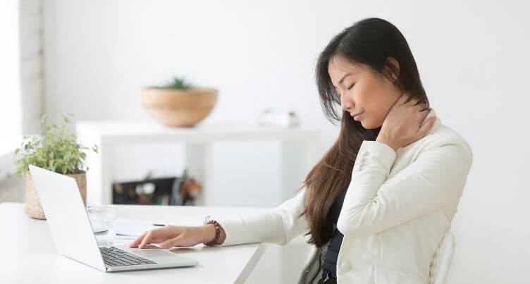 Woman using a laptop computer with poor posture, straining her neck.