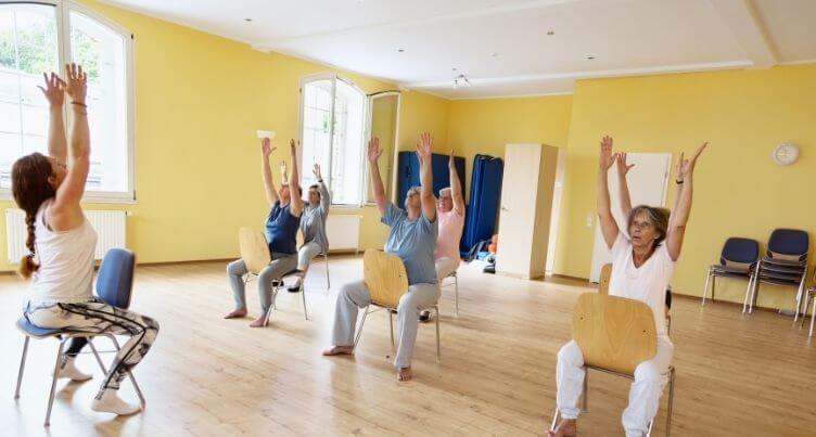 Senior man and woman using exercise bands in a fitness class.
